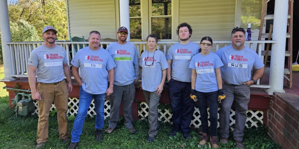 volunteers stand in front of a home