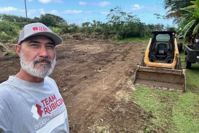 Native Hawaiian volunteer standing near front loader